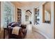 Cozy reading nook with comfortable leather chair, built-in bookshelves, and view into the bright living room at 9552 E Silent Hills Pl, Lone Tree, CO 80124