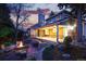 Beautifully landscaped backyard featuring a stone patio with a fire pit, comfortable seating, and evening lighting at 10849 E Crestridge Cir, Englewood, CO 80111