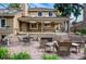 Backyard featuring a stone patio with a fire pit, a dining table, and lush landscaping, perfect for entertaining at 10849 E Crestridge Cir, Englewood, CO 80111