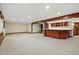 Spacious finished basement with wooden accents, a bar area, and neutral carpet at 10849 E Crestridge Cir, Englewood, CO 80111