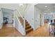 Bright foyer featuring hardwood floors, a white staircase with wooden steps, and access to the living areas at 10849 E Crestridge Cir, Englewood, CO 80111