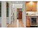 Bright hallway showcasing hardwood floors, a wooden front door with glass accents, and built-in cabinetry with a wine fridge at 10849 E Crestridge Cir, Englewood, CO 80111