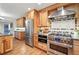 Gourmet kitchen featuring stainless steel appliances, custom cabinetry, granite countertops, and a mosaic tile backsplash at 10849 E Crestridge Cir, Englewood, CO 80111
