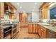 Spacious kitchen with custom wood cabinets, stainless steel appliances, granite countertops, and hardwood floors at 10849 E Crestridge Cir, Englewood, CO 80111