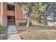 Exterior view of a condo featuring steps leading to the entrance, stone accents, and mature trees at 4294 S Salida Way # 4, Aurora, CO 80013