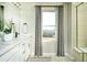 Bright bathroom features a double vanity, mountain view window, and elegant gray accents at 14877 Arbor W Blvd, Thornton, CO 80602