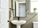 Charming bathroom features a pedestal sink, framed mirror, and decorative wainscoting at 14877 Arbor W Blvd, Thornton, CO 80602