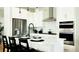 Modern kitchen featuring stainless steel appliances, white cabinetry, and a breakfast bar with stylish pendant lighting at 14877 Arbor W Blvd, Thornton, CO 80602