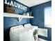 Convenient laundry room with modern washer and dryer, shelving, and natural light at 14877 Arbor W Blvd, Thornton, CO 80602