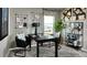 Modern office space with sleek black desk, decor, and large window with mountain views at 14877 Arbor W Blvd, Thornton, CO 80602