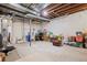 Unfinished basement with exposed ceiling, water filter, and various storage containers at 20290 Doewood Dr, Monument, CO 80132