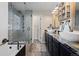 Stylish bathroom with a glass-enclosed shower, soaking tub, and dual vanities with dark cabinets at 20290 Doewood Dr, Monument, CO 80132