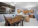 Eat-in kitchen and dining area with light wood cabinets, tile backsplash, and wood-paneled accent wall at 20290 Doewood Dr, Monument, CO 80132