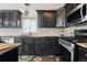 Elegant kitchen with dark cabinetry, modern appliances, and granite countertops at 20290 Doewood Dr, Monument, CO 80132