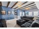 Spacious living room with wooden beams in the ceiling, large sofa, and blue accent walls at 20290 Doewood Dr, Monument, CO 80132