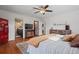 Bright main bedroom featuring a ceiling fan, wooden floors, and a unique Coca-Cola icebox at 20290 Doewood Dr, Monument, CO 80132