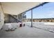 Covered patio with concrete floor, staircase and fenced yard in winter landscape at 20290 Doewood Dr, Monument, CO 80132