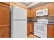 Well-lit kitchen featuring wooden cabinets, white appliances, and laminate countertops at 8422 S Upham Way # G47, Littleton, CO 80128