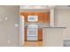 Charming kitchen featuring white appliances, oak cabinets, and a breakfast bar with views of the living area at 8422 S Upham Way # G47, Littleton, CO 80128