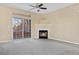 Bright living room with plush carpet, sliding glass door to balcony, and decorative fireplace at 8422 S Upham Way # G47, Littleton, CO 80128