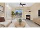 Bright living room with a fireplace, a ceiling fan, and a sliding glass door leading to an outdoor balcony at 8422 S Upham Way # G47, Littleton, CO 80128