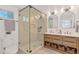Modern bathroom with double vanity, glass shower, and neutral tile at 34 University Dr, Longmont, CO 80503