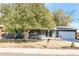 Ranch style home with gray exterior, landscaped yard, and attached garage at 34 University Dr, Longmont, CO 80503