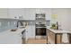 Modern kitchen with white cabinets, herringbone backsplash, and stainless steel appliances at 34 University Dr, Longmont, CO 80503