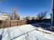 Snowy backyard with wooden fence and neighbor's homes at 245 Dunhill St, Castle Rock, CO 80104