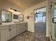 Spa-like bathroom with double sinks, marble countertops, and a view into bedroom at 245 Dunhill St, Castle Rock, CO 80104