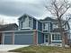 Two-story house with a gray exterior, brick accents, and a three-car garage at 245 Dunhill St, Castle Rock, CO 80104