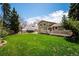 Expansive backyard featuring a well-maintained lawn and a charming wooden deck, perfect for outdoor relaxation at 7863 W Quarto Ave, Littleton, CO 80128