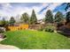Expansive backyard showcasing lush green grass, privacy fence, and mature trees at 7863 W Quarto Ave, Littleton, CO 80128