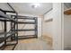Unfinished basement featuring shelving, cabinet storage, and an unfinished floor at 7863 W Quarto Ave, Littleton, CO 80128