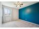 Bedroom with blue accent wall, neutral carpet, and bright window at 7863 W Quarto Ave, Littleton, CO 80128