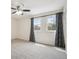 Bedroom with neutral carpet, ceiling fan, and two windows dressed with patterned curtains at 7863 W Quarto Ave, Littleton, CO 80128