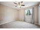 Bedroom with neutral carpet, ceiling fan, and a bright window with curtains at 7863 W Quarto Ave, Littleton, CO 80128