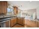 Bright kitchen with stainless steel appliances, tile backsplash, wood cabinets, and hardwood floors at 7863 W Quarto Ave, Littleton, CO 80128