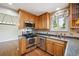Well-lit kitchen features stainless steel appliances, granite countertops and wood cabinets at 7863 W Quarto Ave, Littleton, CO 80128