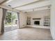 Spacious living room features a decorative brick fireplace and sliding glass door to the yard at 7863 W Quarto Ave, Littleton, CO 80128