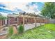 A backyard features a wooden pergola covering a brick patio, complementing the brick exterior and landscaped yard at 457 S Locust St, Denver, CO 80224
