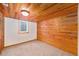 Cozy basement with wood paneled walls, carpeted floor, a small window, and closet for storage at 457 S Locust St, Denver, CO 80224