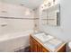 Tiled bathroom featuring a vanity, a bathtub, and a shower with ample storage space at 457 S Locust St, Denver, CO 80224