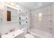 Clean bathroom with white tile, modern fixtures, ample shelf space, and a shower-tub combo at 457 S Locust St, Denver, CO 80224