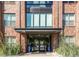 Attractive brick building with a modern glass entrance and manicured landscaping provides a welcoming curb appeal at 155 S Monaco Pkwy # 302, Denver, CO 80224