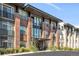 Modern brick apartment building with balconies and landscaping at 155 S Monaco Pkwy # 302, Denver, CO 80224