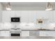 Modern kitchen with white cabinets and stainless steel appliances at 155 S Monaco Pkwy # 302, Denver, CO 80224