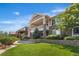 A stunning home featuring a stone facade, covered balcony, and lush green lawn under a bright blue sky at 27485 E Nova Pl, Aurora, CO 80016