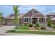 Charming single Gathering home featuring stone and siding exterior, manicured lawn, and a welcoming front porch at 27485 E Nova Pl, Aurora, CO 80016