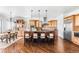 Spacious kitchen features large island with seating, pendant lights, stainless appliances and hardwood floors at 27485 E Nova Pl, Aurora, CO 80016